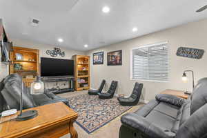Living area with visible vents, baseboards, recessed lighting, and carpet