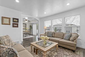 Living room featuring recessed lighting, arched walkways, baseboards, and wood finished floors