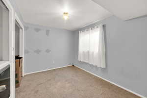 Spare room featuring carpet, a textured ceiling, and baseboards