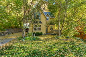 Back of house with stucco siding and a shingled roof