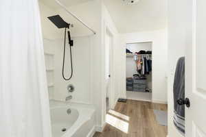 Bathroom with shower / bath combo, and a spacious closet