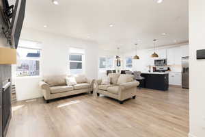 Living area with light wood-style flooring, recessed lighting