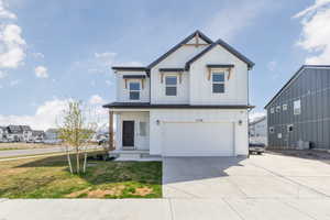 Modern inspired farmhouse featuring driveway, board and batten siding, an attached garage, a front lawn, and central AC