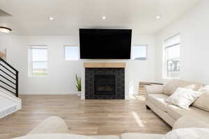 Living area featuring light wood-type flooring, a healthy amount of sunlight, recessed lighting, and stairway