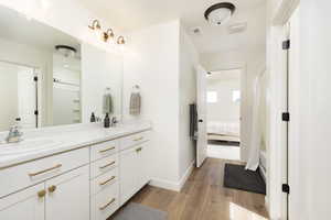 Bathroom featuring wood finished floors, double vanity, a sink,
