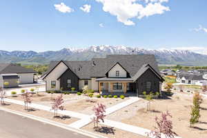 Modern inspired farmhouse featuring a mountain view, a shingled roof, and a porch