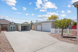 View of front facade with a storage shed, an outdoor structure, fence private yard, and stucco siding