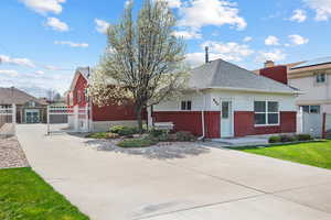 View of front of house featuring brick siding, a front yard, fence, a gate, and concrete driveway