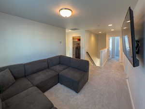 Living area with baseboards, light carpet, recessed lighting, a textured ceiling, and visible vents