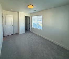 Unfurnished bedroom with carpet flooring, visible vents, and baseboards