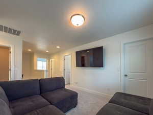 Living room featuring baseboards, recessed lighting, carpet flooring, a textured ceiling, and visible vents