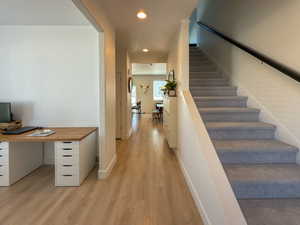 Corridor featuring recessed lighting, light wood-type flooring, stairway, and baseboards