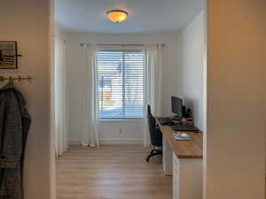 Home office with light wood-style floors and baseboards