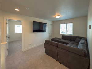 Living area featuring baseboards, light carpet, recessed lighting, a textured ceiling, and visible vents