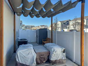 View of patio with a residential view, central air condition unit, a gate, a pergola, and fence