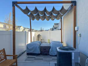 View of patio with a fenced backyard and central air condition unit