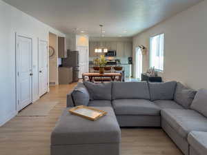 Living area with visible vents, light wood-style flooring, recessed lighting, and a textured ceiling