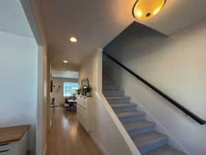 Staircase featuring recessed lighting and wood finished floors