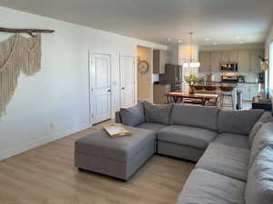 Living room featuring light wood-style floors, baseboards, and recessed lighting