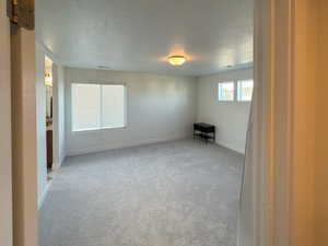 Unfurnished room with a textured ceiling, baseboards, visible vents, and carpet floors