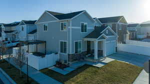 View of front facade featuring a gate, stone siding, fence, a residential view, and driveway