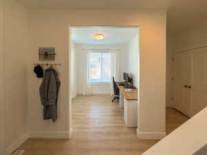 Office space with baseboards and light wood-type flooring
