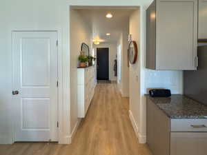 Hallway with light wood-style floors, baseboards, visible vents, and recessed lighting