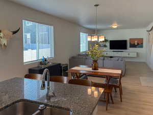 Dining space featuring light wood-style flooring, an inviting chandelier, and baseboards