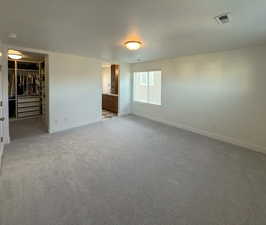 Empty room featuring light carpet, a textured ceiling, and baseboards