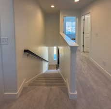 Staircase featuring baseboards, recessed lighting, and carpet