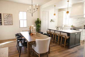 Dining area featuring baseboards, a notable chandelier, and wood finished floors