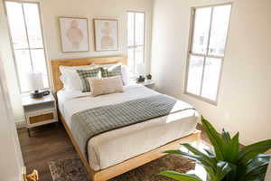 Bedroom with wood finished floors, baseboards, and multiple windows