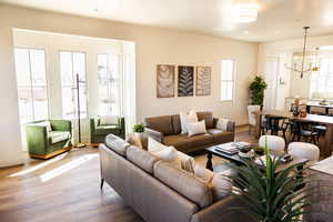 Living area featuring recessed lighting, a notable chandelier, baseboards, and wood finished floors