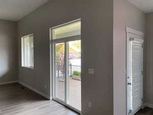 Doorway with baseboards and light wood finished floors