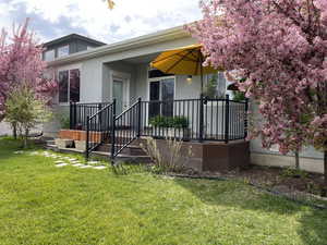 Back of house with stucco siding and a yard