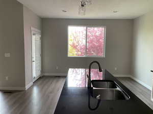 Kitchen featuring baseboards, visible vents, a sink, and light wood-style floors