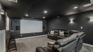 Carpeted home theater with visible vents, baseboards, and recessed lighting