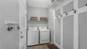 Laundry room with tile patterned floors, separate washer and dryer, laundry area, and baseboards