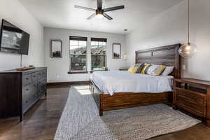 Bedroom with dark wood-type flooring, baseboards, a ceiling fan, and a textured ceiling