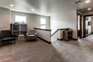 Living area featuring carpet, visible vents, and recessed lighting