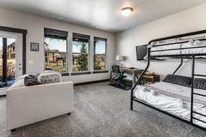 Carpeted bedroom featuring visible vents, access to exterior, baseboards, and a textured ceiling
