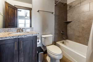 Bathroom featuring ceiling fan, vanity, tile patterned flooring, toilet, and shower / bath combo with shower curtain