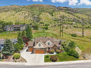 Aerial view of property and surrounding area featuring a mountainous background
