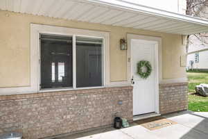 Property entrance featuring brick siding and stucco siding