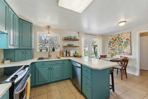 with a peninsula, a healthy amount of sunlight stainless steel appliances