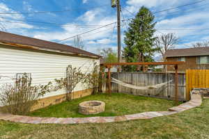 View of yard featuring fence and a fire pit