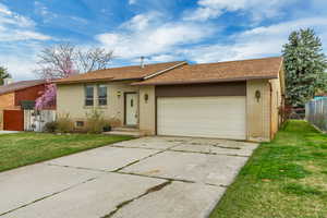 Ranch-style house featuring a front yard, fence, and brick siding