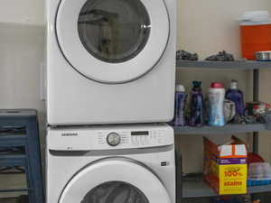 Laundry area in the garage with stacked washer and dryer