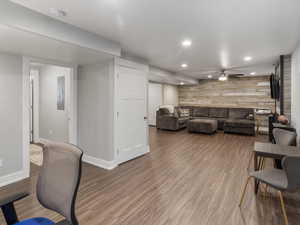 Basement Living area with recessed lighting, an accent wall, a ceiling fan, and LVP floors