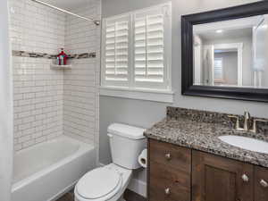 Basement Bathroom Full bathroom with toilet, vanity, shower / bathing tub combination, and baseboards